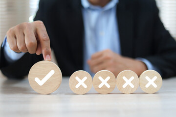 Hand choose check mark with cross symbol on wooden toy stack for true or false changing mindset or way of adapting to change leader and transform quiz answer and poll concept.