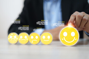 Hand chooses wooden block stack with smile face icon and five-star for customer services rating feedback and satisfaction survey online review questionnaire for service mind marketing.