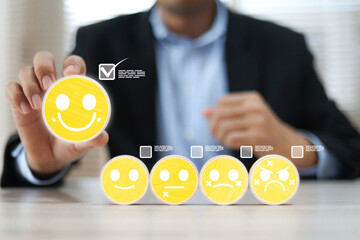Hand chooses wooden block stack with smile face icon and five-star for customer services rating feedback and satisfaction survey online review questionnaire for service mind marketing.
