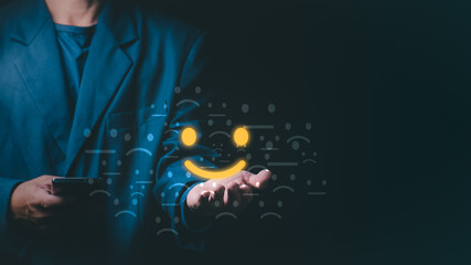 Businessman holding a glowing yellow smiley face icon representing customer satisfaction, positive feedback, and excellent service experience amidst various faded emotional emojis on dark background