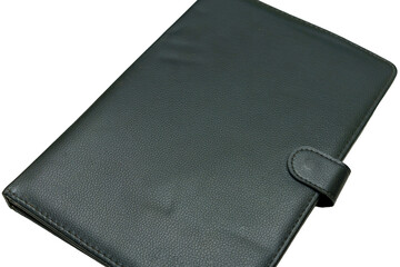 Black leather notebook with a clasp on a plain background in soft lighting