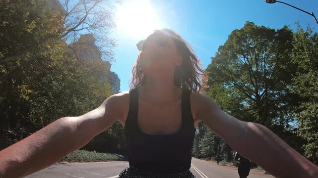 Young female tourist enjoying the bike ride in Cental Park, New York in midtown Manhattan. Central Park is on of the main attraction for tourists in New York
