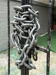 Steel chain wrapped around a metal gate on a street.