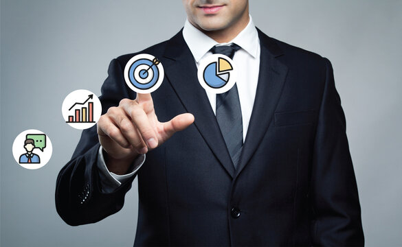 Businessman pointing at virtual holographic interface with business growth icons. - Powered by Adobe