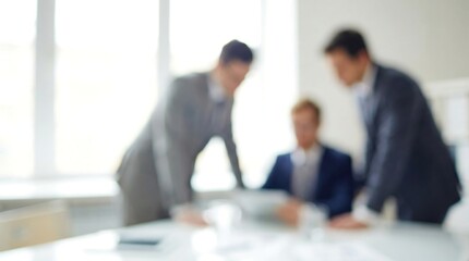 a blurred image depicts three business professionals seemingly engaged in a discussion over a document on a table in an office setting