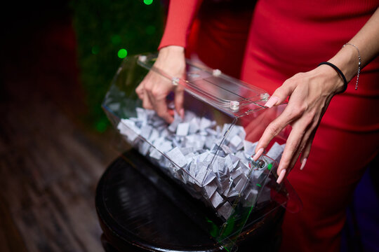 Guests select raffle tickets eagerly, People reach into box to pick lucky raffle slip, Participants eagerly reach into transparent container for their chance to win prize