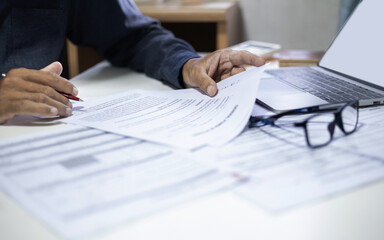 businessman or professional lawyer reviewing document at office. legal expert working with laptop...