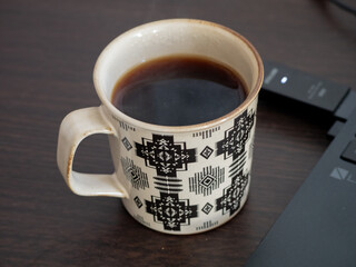 ノートパソコンと淹れたてのコーヒー