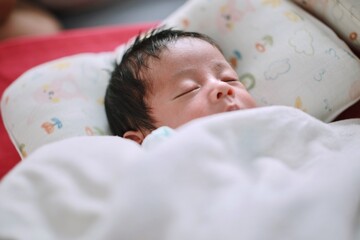 Newborn baby sleeping in bed