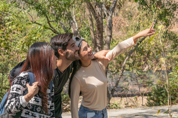 Happy Multi-ethnicity group of young friends enjoy hiking, walking, exploring in forest on vacation, female and man having fun in forest on beautiful autumn day, nature outdoor wild grass forest trip.