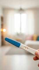 Pregnancy test held in hand, displaying results in a bright, softly lit living room with blurred background elements, symbolizing anticipation and hope for future family planning
