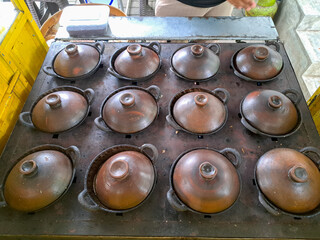 The process of making serabi. Serabi is made from a mixture of flour, coconut milk, and palm sugar, baked in small earthenware pans. It's delicious as a snack or breakfast.