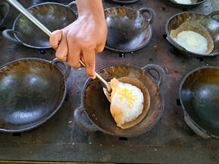 The process of making serabi. Serabi is made from a mixture of flour, coconut milk, and palm sugar, baked in small earthenware pans. It's delicious as a snack or breakfast.