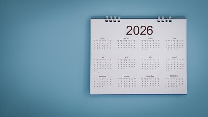 White calendar laying on blue background planning concept.