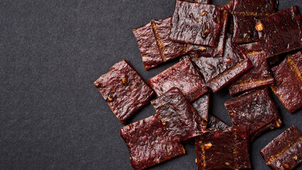 flat lay jerky pork on black background with copy space