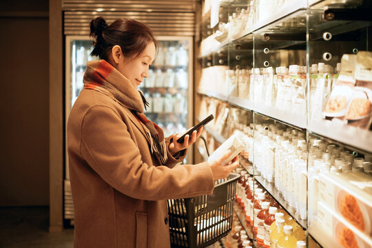 Woman Shopping for Products with Smartphone in Store
