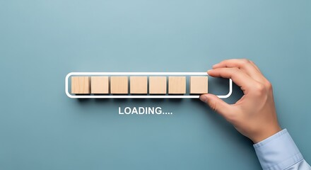 Hand placing the final wooden block to complete a digital loading bar process concept