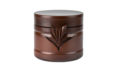 A close-up, studio shot shows a beautifully crafted, round, wooden container. A decorative leaf design is carved on the front