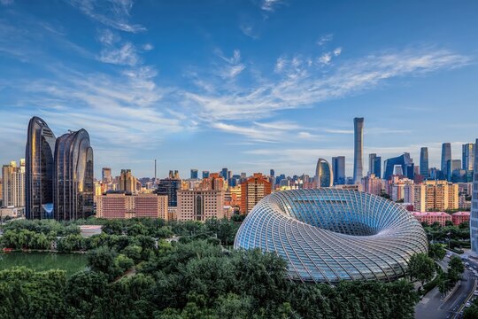 A stunning view of the Beijing Phoenix Center and CBD skyline, showcasing modern architecture with lush green surroundings under a vibrant sky.
