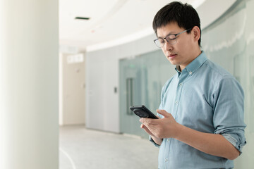 asian man using smart phone in office