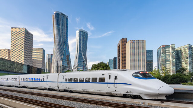 High-speed train passing modern city skyscrapers