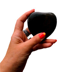 Hand holding a black heart-shaped stone against a transparent background