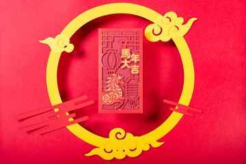 red pocket for Chinese New Year of the Horse with traditional Chinese decorations translation of the Chinese characters are Good luck in the Year of the Horse no logo no trademark