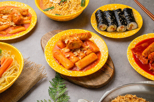 Poster-style image featuring a wide variety of Korean street foods such as tteokbokki, fried snacks, udon, chicken, gimbap, ramen, and sundae. Suitable for use in food advertising, restaurant menus,