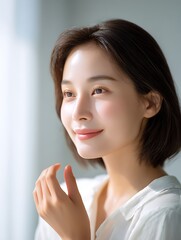 Radiant woman nourishing her skin with facial cream