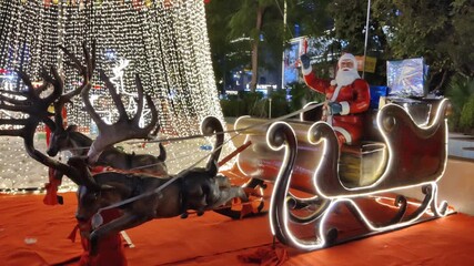 Jaipur, India 24 December 2025: Footage of Christmas decoration in a mall in Jaipur on Christmas eve shot against dark background. Santa Claus rides on a reindeer
