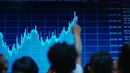 A group of children watches a stock market presentation at school. They point to graphs and data on a large screen, learning about market fluctuations and trends - Powered by Adobe