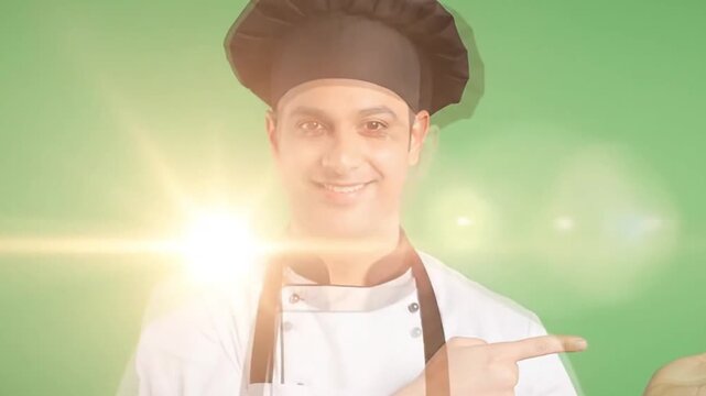 A professional chef in a white uniform and toque smiles confidently while pointing to commercial copy space.