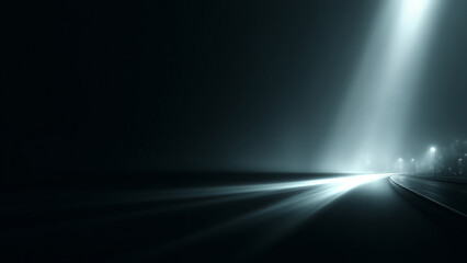 Bright white spotlight beam shining on dark road surface