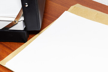 Close-up of office desk with papers symbolizing investigation, reports, or contracts. Blank papers
