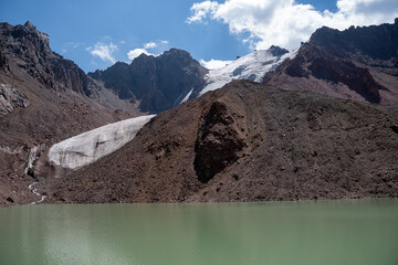 Scientific equipment at the turquoise Manshuk Mametova glacier lake. High-altitude environmental research in Tien Shan mountains, Central Asia.