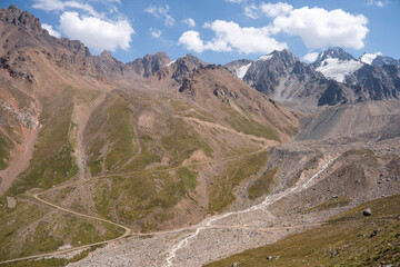 High-altitude mountain pass in the Trans-Ili Alatau range. Gravel road among Tuyuk-Su glaciers and rocky valleys, Tien Shan, Central Asia