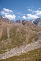 High-altitude mountain pass in the Trans-Ili Alatau range. Gravel road among Tuyuk-Su glaciers and rocky valleys, Tien Shan, Central Asia
