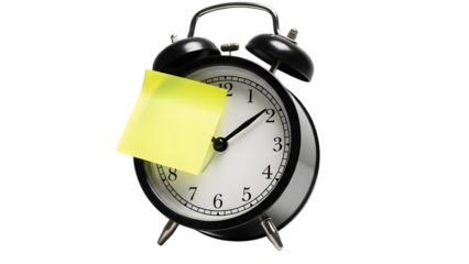 Vintage black alarm clock with yellow sticky note on face