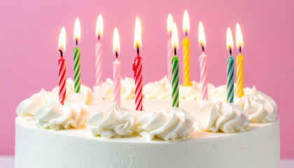 Birthday cake with colorful candles on pink background