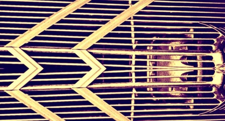 An artistic close-up of a metallic grille, likely from a vintage vehicle. Horizontal slats and...