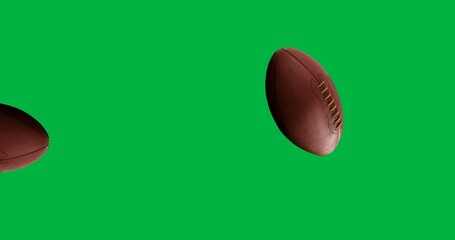 Digital animation of multiple rugby balls falling against black background