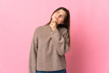 Young slovak woman isolated on pink background and looking up