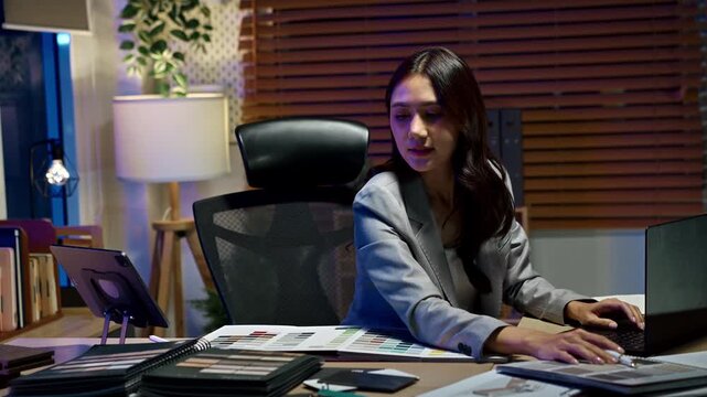 Women interior designer working in office at night.