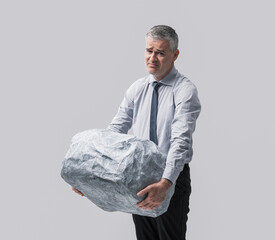 A Businessman Lifting a Heavy Boulder with His Hands
