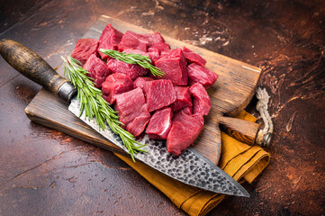 Diced Raw Venison meat, fresh Wild Roe Deer Game Meat on butcher cutting board. brown background. top view © Mironov