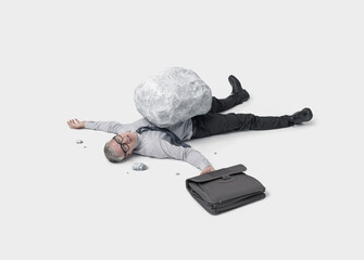 A Businessman Lying on the Ground Covered by a Huge Boulder While Holding a Briefcase