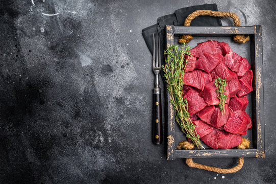 Diced Roe Deer meat, raw Venison Wild Game Meat. black background. top view
