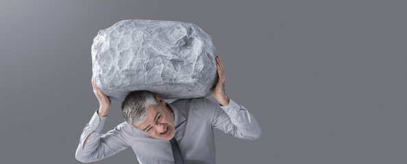 A Businessman Struggling to Hold a Heavy Boulder Above His Head