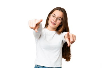 Teenager girl over isolated chroma key background pointing front with happy expression