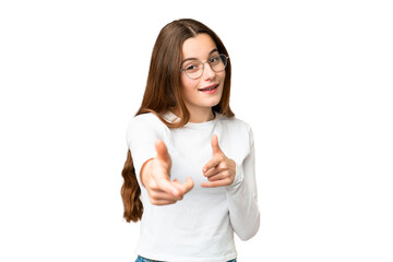 Teenager girl over isolated chroma key background pointing to the front and smiling